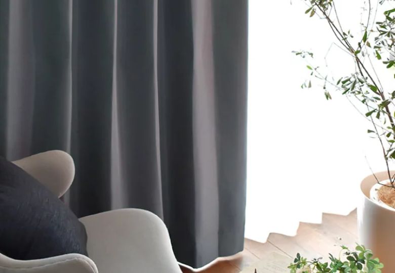 Mảng rèm xám đậm buông dài tạo điểm tựa thị giác đầy chiều sâu cho căn phòng