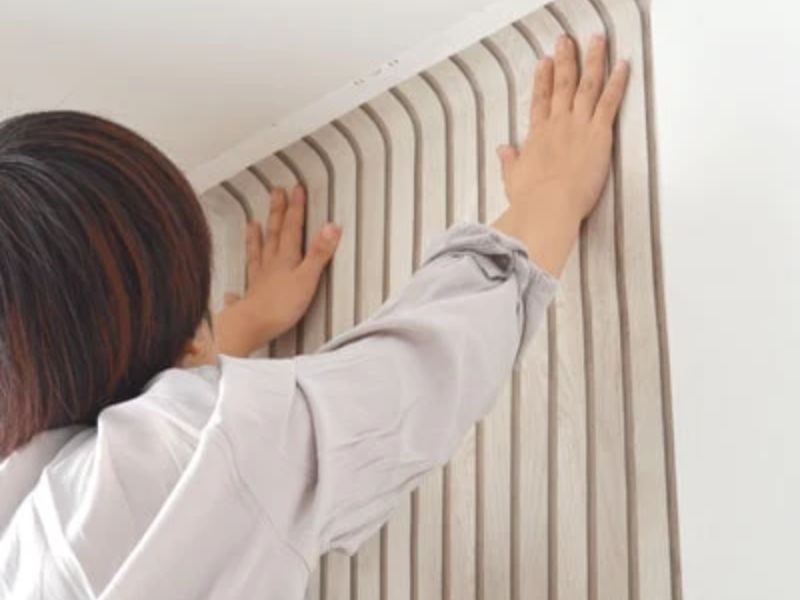 3. Bóc lớp giấy lót phía sau một chút và dán giấy dán tường bắt đầu từ mép trái của tường.